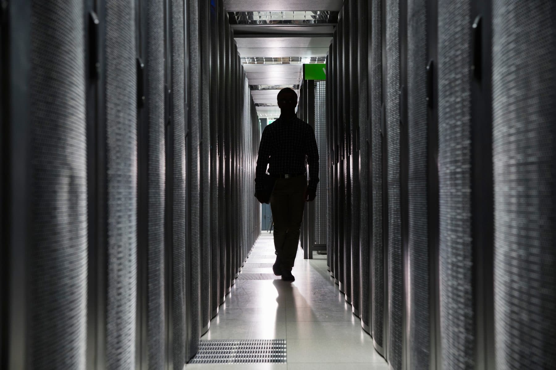 An engineer walking down a data centre aisle