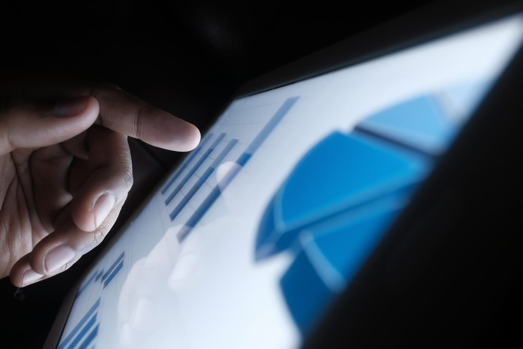 A hand tracing a chart on a tablet